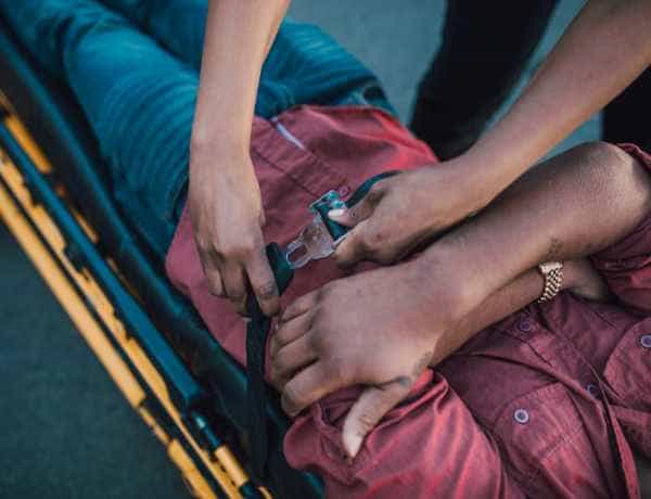 injured persons strapped to gurney